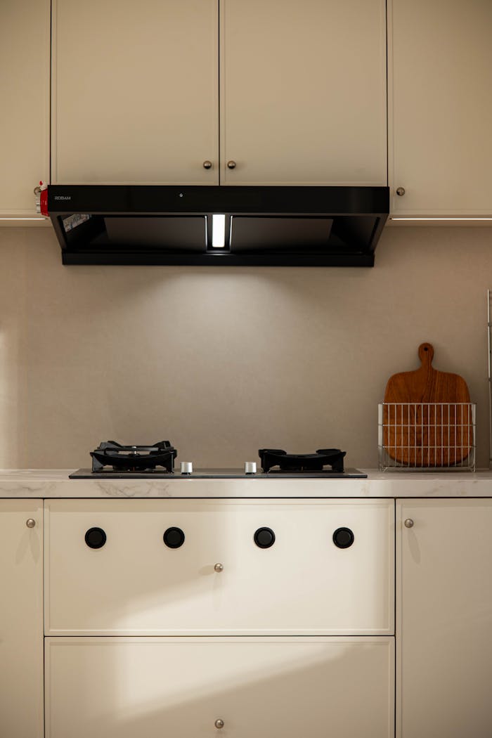 Clean and modern kitchen design with stovetop and chopping board.